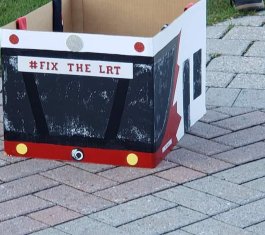 Box that looks like the front of an OC Transpo bus with "Fix The LRT" written on it